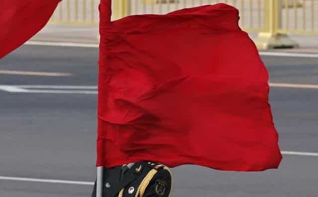 The wind blows a red flag onto the face of an honour guard before a welcome ceremony for Australia's Prime Minister Julia Gillard outside the Great Hall of the People in Beijing April 9, 2013. (Photo by Kim Kyung-Hoon/Reuters)