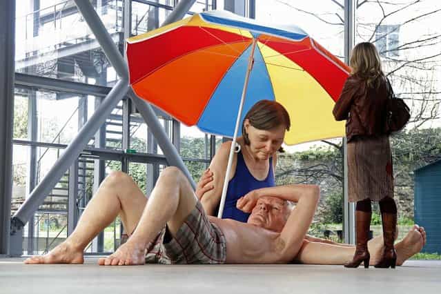 A visitor looks at a sculpture entitled [Couple Under an Umbrella, 2013] by artist Ron Mueck during the press day for his exhibition at the Fondation Cartier pour l'art contemporain in Paris April 15, 2013. (Photo by Charles Platiau/Reuters)