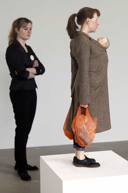 A visitor looks at a sculpture entitled [Woman with Shopping, 2013] by artist Ron Mueck during the press day for his exhibition at the Fondation Cartier pour l'art contemporain in Paris April 15, 2013. (Photo by Charles Platiau/Reuters)