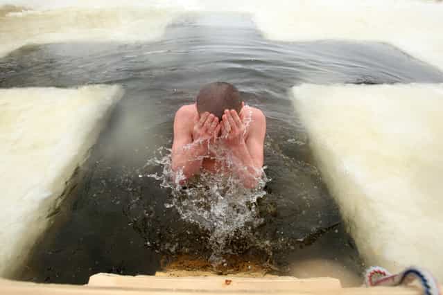 A Russian Orthodox believer plunges herself into icy waters as part of Epiphany holiday celebrations in Kolpino, not far from St. Petersburg on January 19, 2011. (Photo by Kirill Kudrjavcev)