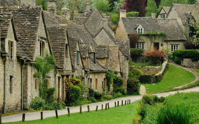 Arlington Row, Bibury, UK was built in 1380 as a monastic wool store. The buildings were converted into weaver cottages in the 17th century. (Photo by Saffron Blaze)