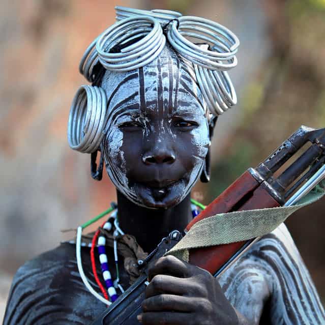 Ethiopia: Valley of the Omo, Mursi; a woman with a Kalashnikov. (Claude Gourlay)