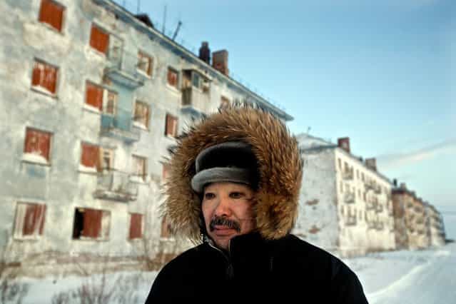 Karp Belgayev, a coal miner, walks through his abandoned Arctic town where he is among the last ten inhabitants. Most others have left after the closure of the Soviet-era coal mine. Coal dust gathered around his eyes left unwashed during years working in the Arctic cold has left permanent black rings. (Photo by Justin Jin/2013 Sony World Photography Awards)