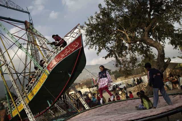 Pakistani children enjoy jumping on a trampoline, at a Christian neighborhood for Christmas holiday in Islamabad, Pakistan, Monday, December 24, 2012. (Photo by Muhammed Muheisen/AP Photo)
