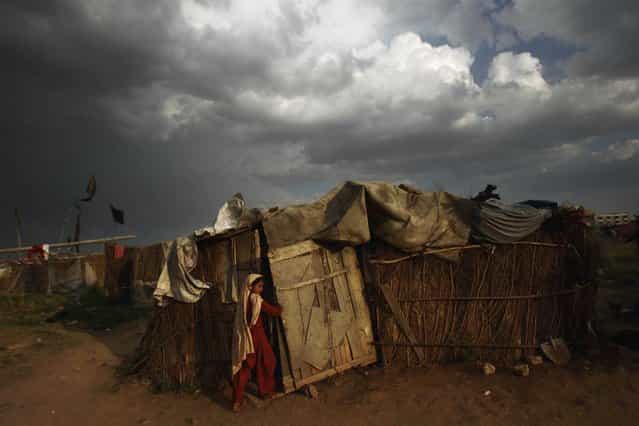 A Pakistani girl enters her home in a slum in Islamabad, on April 14, 2012. (Photo by Muhammed Muheisen/AP Photo)