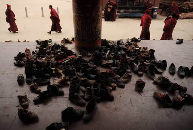 This photo taken on April 4, 2013 shows apprentice Buddhist monks leaving their shoes outside before a debating session in Seda Monastery, the largest Tibetan Buddhist school in the world, with up to 40,000 monks and nuns in residence for some parts of the year. Seda, known to Tibetans as Serthar is located in Ganzi prefecture in the west of China's Sichuan province and has become a hotbed of protests and violence since the Tibetan uprisings of March 2008. More than 110 Tibetans have set themselves alight since 2009, with most dying of their injuries, in demonstrations against what they view as Chinese oppression which Beijing rejects pointing to substantial investment in Tibet and other regions with large Tibetan populations, although critics say economic development has brought an influx of ethnic Han Chinese and eroded traditional Tibetan culture. (Photo by Peter Parks/AFP Photo)