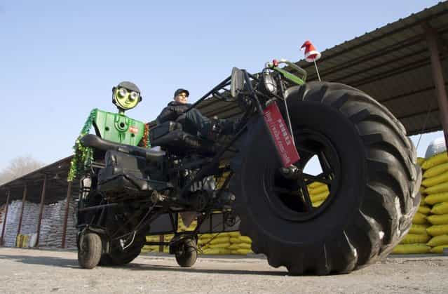 Zhang Yali, 49, tests a giant bicycle designed and made by him and his friends outside a rented warehouse in Jilin, Jilin province, China, December 25, 2011. The 3.2-metre-high and 5.5-metre-long three-seated giant bicycle, weighing over one tonne, cost Zhang more over 20,000 yuan (3,156 USD). Zhang spent two months making this bike as a gift for his son, a 25-year-old part-time cartoonist currently living in Shenzhen, Guangdong province. (Photo by Reuters/China Daily)