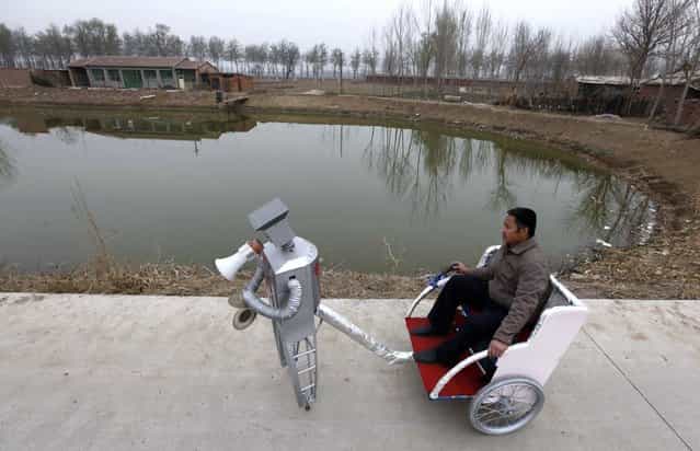 Farmer Wu Yulu, 48, rides in a cart pulled by his walking robot near his home in a village at the outskirts of Beijing April 14, 2010. Hobby inventor Wu, who started to build robots in 1986, has invented 47 robots with different functions like jump, paint, drink, pull cart, massage, and help cooking. He will display more than 30 his robots during Shanghai World Expo 2010, and he wants to promote his practical robots into market by the Expo. (Photo by Petar Kujundzic/Reuters)