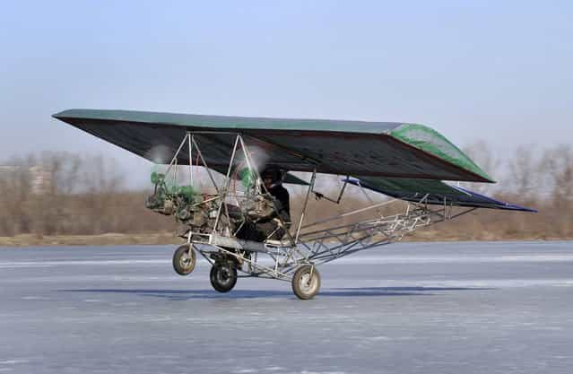 Ding Shilu, an automobile mechanic, carries out a test-flight for his self-made aircraft at a frozen reservoir in Shenyang, Liaoning province February 25, 2011. The aircraft which weights about 130 kg (287 lbs) and made of recycled materials including three motorbike engines and plastic cloth, cost about 2600 yuan ($395), local media reported. (Photo by Reuters/Stringer)