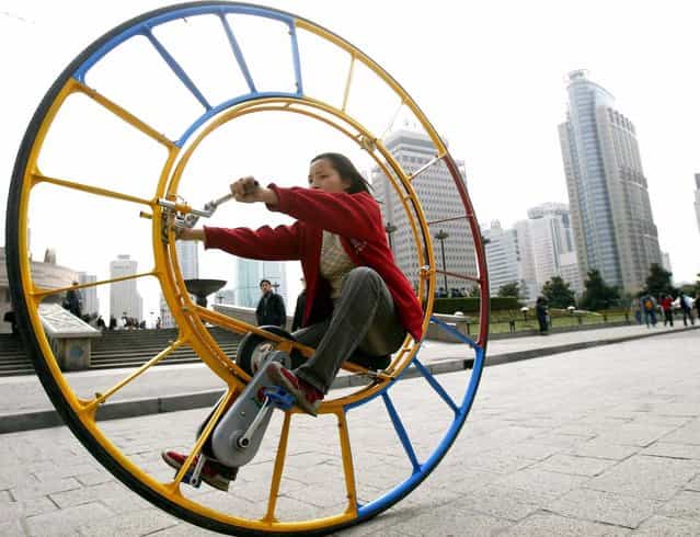 A woman rides an unicycle at a park in Shanghai February 28, 2004. The unicycle was designed by Chinese inventor Li Yongli who called it [the number one vehicle in the world]. (Photo by Reuters/China Photos)