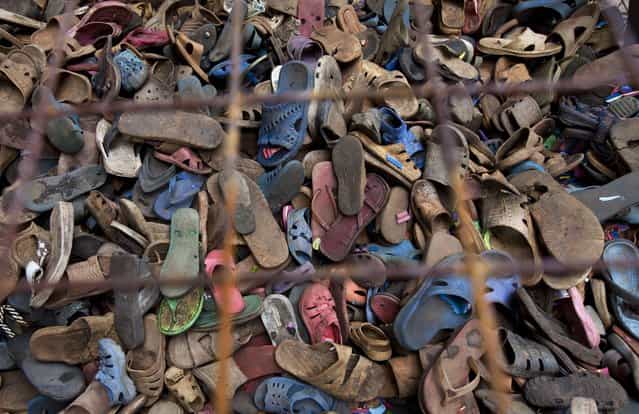 In this photo taken Monday, April 29, 2013, a pile of discarded flip-flops sits in a crate ready to be washed, sorted, and carved into toy animals, at the Ocean Sole flip-flop recycling company in Nairobi, Kenya. The company is cleaning the East African country's beaches of used, washed-up flip-flops and the dirty pieces of rubber that were once cruising the Indian Ocean's currents are now being turned into colorful handmade giraffes, elephants and other toy animals. (Photo by Ben Curtis/AP Photo)