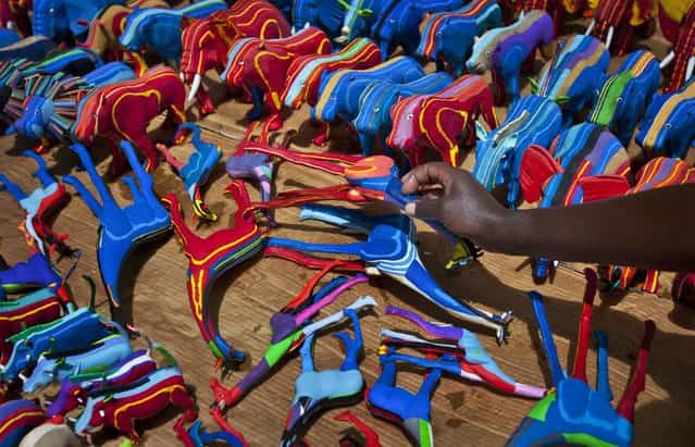In this photo taken Monday, April 29, 2013, finished toy animals made from pieces of discarded flip-flops are laid out in rows to dry in the sun, having just been washed, at the Ocean Sole flip-flop recycling company in Nairobi, Kenya. The company is cleaning the East African country's beaches of used, washed-up flip-flops and the dirty pieces of rubber that were once cruising the Indian Ocean's currents are now being turned into colorful handmade giraffes, elephants and other toy animals. (Photo by Ben Curtis/AP Photo)