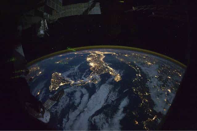This image provided by NASA shows parts of Europe and Africa very easily recognizable in this night time image shot by one of the Expedition 25 crew members aboard the International Space Station flying 220 miles above Earth on Thursday Oct. 28, 2010. The view [looks] northward over Sicily and the [boot] of Italy, with the Mediterranean Sea representing most of the visible water in the view and the Adriatic Sea to the right of center. Tunisia is partially visible at left. Part of a docked Russian spacecraft and other components of the ISS are in the foreground. (Photo by AP photo/NASA)