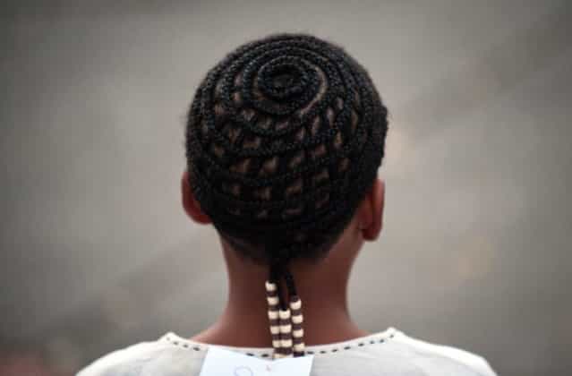 A man presents an Afro-Colombian hairstyle during the 9th contest of Afro-hairdressers, in Cali, Valle del Cauca departament, Colombia, on May 12, 2013. The Afro hairstyles have their origins in the time of slavery, when women sat to comb their children hair after work. (Photo by Luis Robayo/AFP Photo)