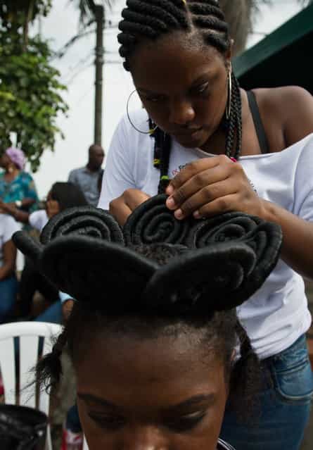 A woman gets an Afro-Colombian hairstyle during the 9th contest of Afro-hairdressers, in Cali, Valle del Cauca departament, Colombia, on May 12, 2013. The Afro hairstyles have their origins in the time of slavery, when women sat to comb their children hair after work. (Photo by Luis Robayo/AFP Photo)