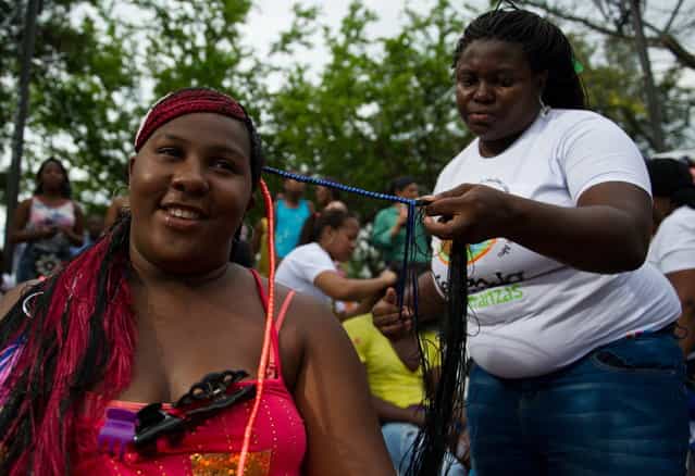 A woman gets an Afro-Colombian hairstyle during the 9th contest of Afro-hairdressers, in Cali, Valle del Cauca departament, Colombia, on May 12, 2013. The Afro hairstyles have their origins in the time of slavery, when women sat to comb their children hair after work. (Photo by Luis Robayo/AFP Photo)