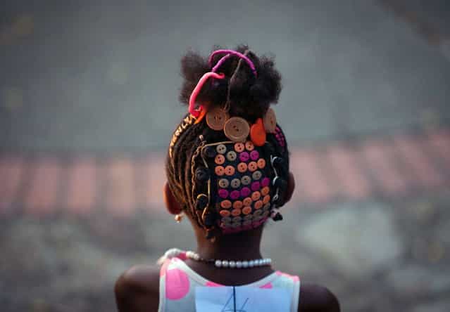 A girl presents an Afro-Colombian hairstyle during the 9th contest of Afro-hairdressers, in Cali, Valle del Cauca departament, Colombia, on May 12, 2013. The Afro hairstyles have their origins in the time of slavery, when women sat to comb their children hair after work. (Photo by Luis Robayo/AFP Photo)