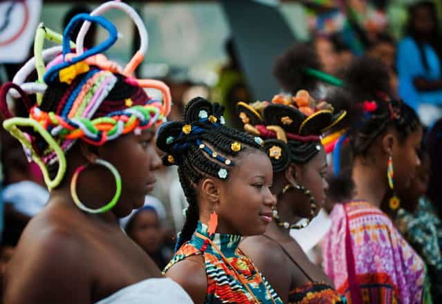 Girls present African-Colombian hairstyles during the 9th contest of Afro-hairdressers, in Cali, Valle del Cauca departament, Colombia, on May 12, 2013. The Afro hairstyles have their origins in the time of slavery, when women sat to comb their children hair after work. (Photo by Luis Robayo/AFP Photo)