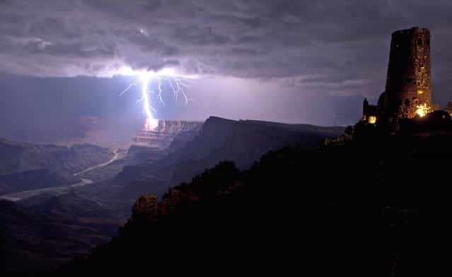 This is the incredible moment a fierce lightning bolt crashed against the Grand Canyon illuminating the steep canyon walls. Shrouded in darkness, the breath-taking landscape was shocked into life as mother nature sent the bolt storming down to Earth. As it cracked against the rocks the bright blue bolt illuminated the South Rim of the canyon, considered one of the Seven Natural Wonders of the World. With just the Desert View Watchtower in the foreground, the lightning was perfectly framed by the canyon which is located in Arizona, USA. (Photo by Travis Roe/U.S. Dept. of the Interior/Caters News)