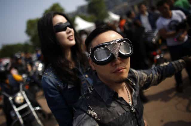A couple rides a Harley Davidson motorcycle during the annual Harley Davidson National Rally in Qian Dao Lake, in Zhejiang Province May 11, 2013. Around 1,000 Harley Davidson enthusiasts from all over China met to celebrate the 5th Harley Davidson National Rally in China, as part of the company's 110-year anniversary. Major Chinese cities ban motorcycles from circulating on highways and major avenues. Meanwhile, Harley Davidson motorbikes are considered by Chinese tax authorities to be luxury items, so they are taxed at extremely high rates – sometimes the taxes alone is equivalent to the bike's U.S. price tag. Traffic and transportation authorities have also weighed in, putting Harleys in the same category as electric bikes, horses and bicycles, meaning that they cannot be on highways and major avenues. (Photo by Carlos Barria/Reuters)
