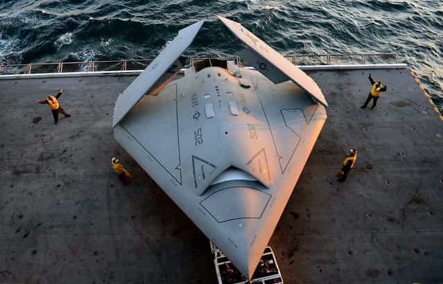 In this handout released by the U.S. Navy, Sailors move an X-47B Unmanned Combat Air System (UCAS) demonstrator onto an aircraft elevator aboard the aircraft carrier USS George H.W. Bush (CVN 77) May 14, 2013 in the Atlantic Ocean. George H.W. Bush is scheduled to be the first aircraft carrier to catapult-launch an unmanned aircraft from its flight deck. The Navy plans to have unmanned aircraft on each of its carriers to be used for surveillance and be armed and used in combat roles. (Photo by Mass Communication Specialist 2nd Class Timothy Walter/U.S. Navy via Getty Images)