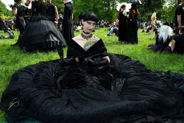 A woman in a black dress sits on the lawn during the traditional park picnic on the first day of the annual Wave-Gotik Treffen, or Wave and Goth Festival, on May 17, 2013 in Leipzig, Germany. The four-day festival, in which elaborate fashion is a must, brings together over 20,000 Wave, Goth and steam punk enthusiasts from all over the world for concerts, readings, films, a Middle Ages market and workshops. (Photo by Marco Prosch)