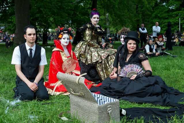 Participants in costumes attend the traditional park picnic on the first day of the annual Wave-Gotik Treffen, or Wave and Goth Festival, on May 17, 2013 in Leipzig, Germany. The four-day festival, in which elaborate fashion is a must, brings together over 20,000 Wave, Goth and steam punk enthusiasts from all over the world for concerts, readings, films, a Middle Ages market and workshops. (Photo by Marco Prosch)
