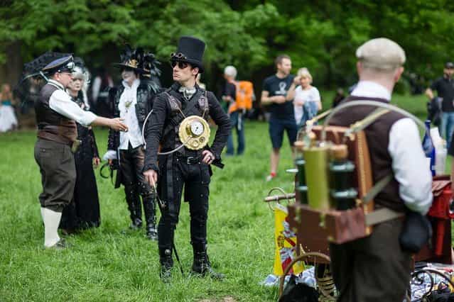 A man dressed in a steam-punk costume attends the traditional park picnic on the first day of the annual Wave-Gotik Treffen, or Wave and Goth Festival, on May 17, 2013 in Leipzig, Germany. The four-day festival, in which elaborate fashion is a must, brings together over 20,000 Wave, Goth and steam punk enthusiasts from all over the world for concerts, readings, films, a Middle Ages market and workshops. (Photo by Marco Prosch)
