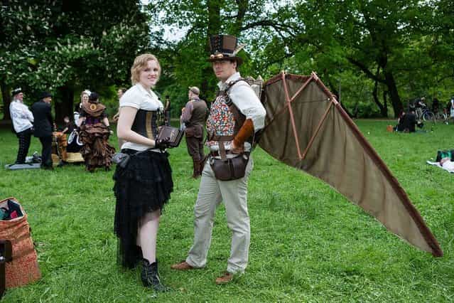 A man in a steam-punk outfit with self-made wings and a woman in Victorian clothing holding the book 'The Hobbit' attend the traditional park picnic on the first day of the annual Wave-Gotik Treffen, or Wave and Goth Festival, on May 17, 2013 in Leipzig, Germany. The four-day festival, in which elaborate fashion is a must, brings together over 20,000 Wave, Goth and steam punk enthusiasts from all over the world for concerts, readings, films, a Middle Ages market and workshops. (Photo by Marco Prosch)