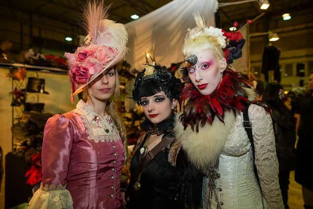 Three girls in Victorian clothing pose for pictures at the Agra festival area on the first day of the annual Wave-Gotik Treffen, or Wave and Goth Festival, on May 17, 2013 in Leipzig, Germany. The four-day festival, in which elaborate fashion is a must, brings together over 20,000 Wave, Goth and steam punk enthusiasts from all over the world for concerts, readings, films, a Middle Ages market and workshops. (Photo by Marco Prosch)