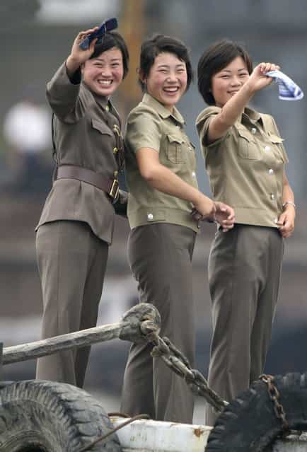 Female North Korean soldiers wave to a Chinese boat for tourists on the banks of Yalu River near the North Korean town of Sinuiju July 27, 2010. (Photo by Jacky Chen/Reuters)