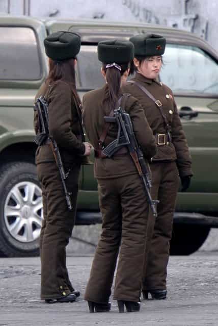 In this Thursday, April 11, 2013 photo, North Korean female soldiers stand watch on the river bank of the North Korean town of Sinuiju, opposite to the Chinese border city of Dandong. (Photo by AP Photo)
