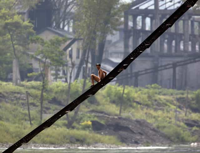 A North Korean man comes down a ladder in front of a disused factory along the banks of the Yalu River near the North Korean town of Qing Cheng, located around 50 kilometres north of the Chinese border city of Dandong September 12, 2008. (Photo by David Gray/Reuters)