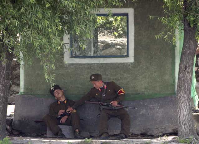 North Korean soldiers guard the bank of Yalu River near the North Korean town of Sinuiju, opposite the Chinese border city of Dandong, July 3, 2009. (Photo by Jacky Chen/Reuters)
