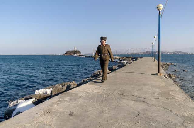 A female soldier walks down a jetty in Wonsan, Feburary 2012. (Eric Testroete)
