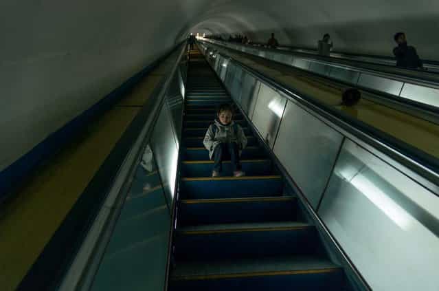 A girl sits on the escalator at the Pyongyang metro, Feburary 2012. (Eric Testroete)