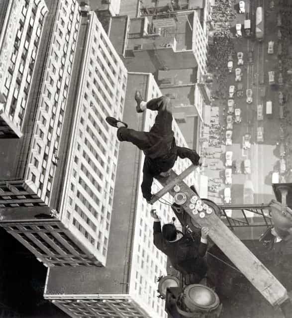A man balancing on a piece of wood on the roof of a skyscraper. New York, USA, 1939. (Photo by Hulton Archive)
