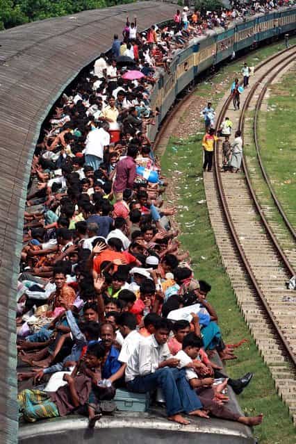 Muslim passengers sit on top of a crowded train in Dhaka, Bangladesh. Hundreds of Bangladeshi Muslims are heading home to celebrate Eid al-Fitr, a Muslim feast marking the end of the holy fasting month of Ramadan. (Photo by Pavel Rahman/Associated Press)