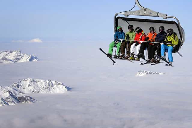 Skiers are seen on a cable car above the fog on December 1, 2012 in the Titlis mountain above Engelberg, Central Switzerland. (Photo by Fabrice Coffrini/AFP Photo)