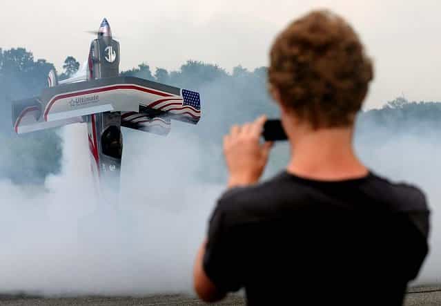 A visitor to the Jet-Flugtage model aircraft festival takes pictures of a remote-controlled replica of the U.S. double-decker [Ultimate Dash 300 S] at the airport in Ganderkesee, Germany. (Photo by Ingo Wagner/AFP Photo)