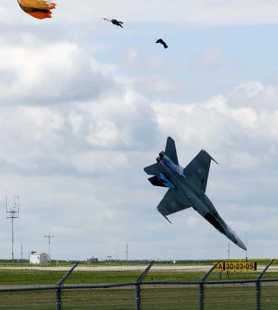 Pilot Capt. Brian Bews parachutes to safety as his CF-18 fighter jet plummets to the ground during a practice flight for a weekend airshow at the Lethbridge County Airport in Alberta, Canada. (Photo by Ian Martens/Lethbridge Herald/The Canadian Press/Associated Press)