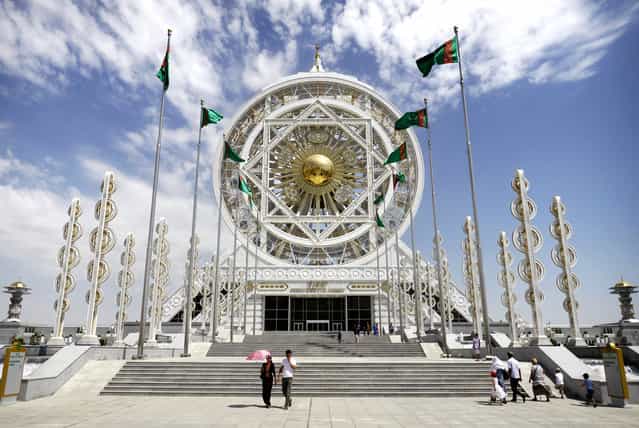 A young couple leave the Alem Entertainment Center in Ashgabat. The current president has a history of breaking obscure records. In 2012 the wheel atop this complex was entered into the Guinness Book of World Records as the world's largest enclosed Ferris wheel. The structure was built at a cost of $90m. (Photo by Amos Chapple via The Atlantic)