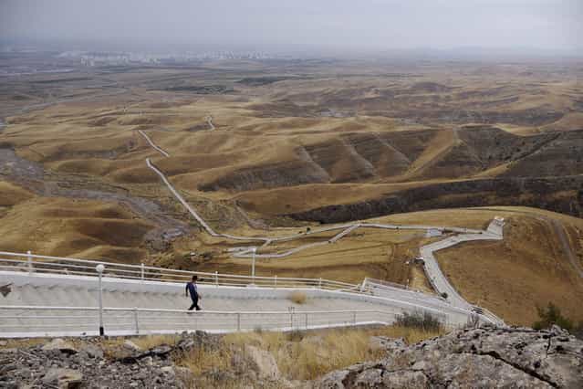 The Serdar Health Path, winding into the hills south of Ashgabat. The 8km track features prominently in the country's annual [Health Week]. In 2000, former president Saparmurat Niyazov made an example of his entire cabinet, cheering them them on as they struggled their way up the path – he'd been flown to the top by helicopter. (Photo by Amos Chapple via The Atlantic)