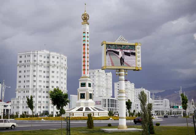 A giant thermometer, and a screen playing a loop of official ceremonies in the center of Ashgabat. (Photo by Amos Chapple via The Atlantic)