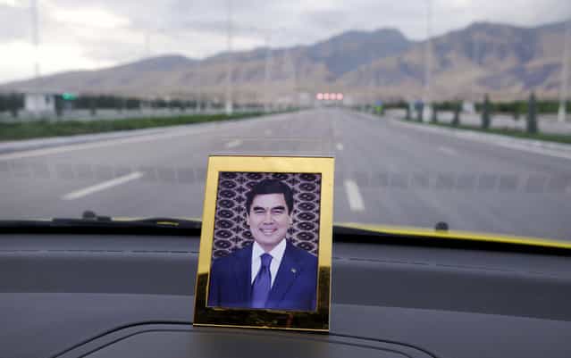 A portrait of the current president Gurbanguly Berdimuhamedow on a dashboard of a taxi. The former dentist took over the presidency after the death of Niyazov in 2006. Most of the bizarre excesses of his predecessor were swiftly rolled back, but on civil liberties and human rights, he's in less of a rush, telling a reporter [never run to where you can simply walk]. (Photo by Amos Chapple via The Atlantic)
