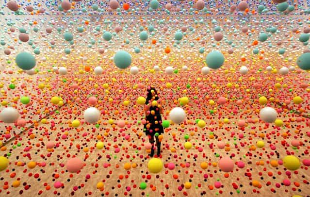Australian artist Nike Savvas makes final adjustments to her art piece consisting of over 50,000 polystyrene balls at the New South Wales Art Gallery in Sydney August 3, 2006. The sculpture titled [Atomix – Full of Love, Full of Wonder], vibrates with wind from 10 fans and represents the different [shimmering] colours in a hot, outback landscape. It is part of a sculpture exhibition [Adventures with Form in Space]. (Photo by David Gray/Reuters)