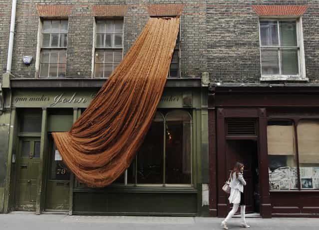 Hundreds of meters of dolls' hair cascades from the window of the Riflemaker gallery, part of an installation by French/Algerian artist Alice Anderson in London April 16, 2010. (Photo by Luke MacGregor/Reuters)