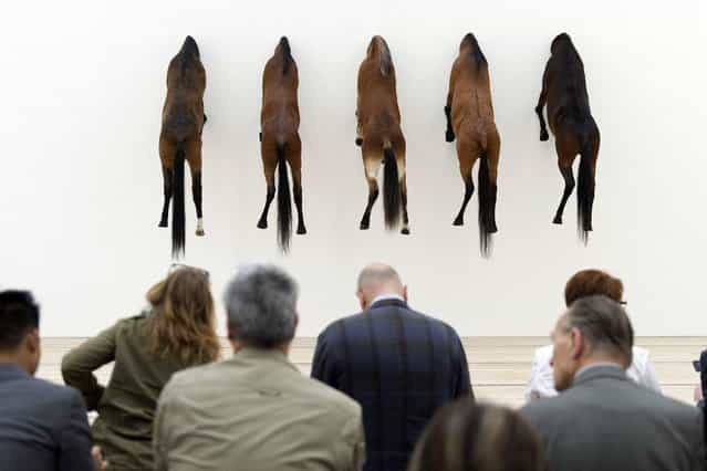 Visitors sit in the exhibition [KAPUTT] (Edition of 3 plus 2 artist's proofs of [Untitled], 2007, Taxidermied Horses) by Italian artist Maurizio Cattelan in the Fondation Beyeler in Riehen, Switzerland, Monday, June 10, 2013. The exhibition lasts from June 8 to Oct. 6, 2013. (Photo by Georgios Kefalas/AP Photo/Keystone)
