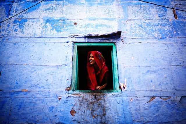 [Indian Smiles]. She opens the window and feels so curious about the new Chinese faces in the old Jodhpur streets around her house. What a beautiful saree and pretty smile! (Photo and caption by Mac Kwan/National Geographic Traveler Photo Contest)