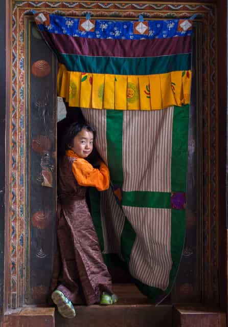[Girl at the door]. I found this girl in a monastery in Jakar, posing at the door of the main entrance to the chapel. Location: Jakar, Bhutan. (Photo and caption by Juan Abal Lopez/National Geographic Traveler Photo Contest)